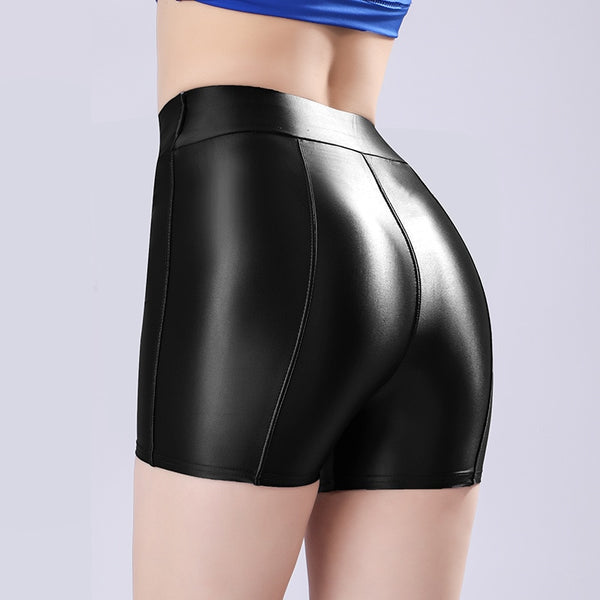 Back view of lady wearing a black color shorts featuring a wide waistband for all-day comfort and a seductive glossy fabric.