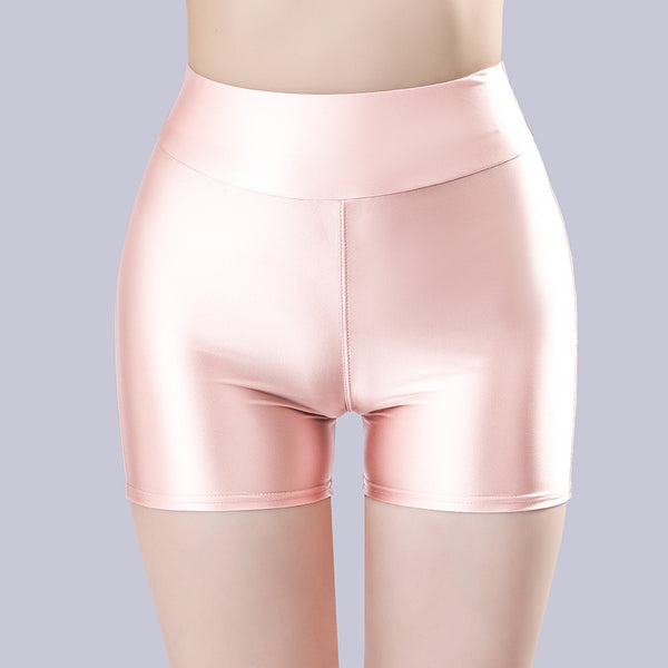 Front view of lady wearing a pink color shorts featuring a wide waistband for all-day comfort and a seductive glossy fabric.