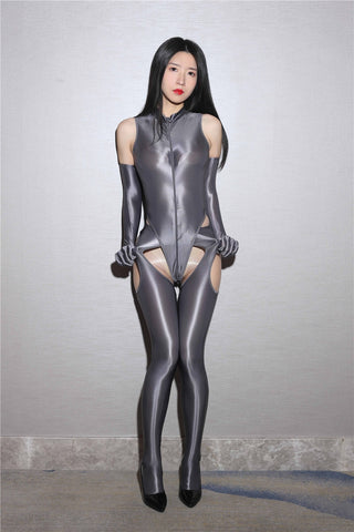 A woman in a gray glossy bodysuit, matching elbow length gloves and suspender style pantyhose posing for a picture.