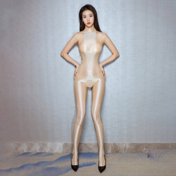 A woman posing in a beige crotchless halter neck glossy catsuit with black high heels.