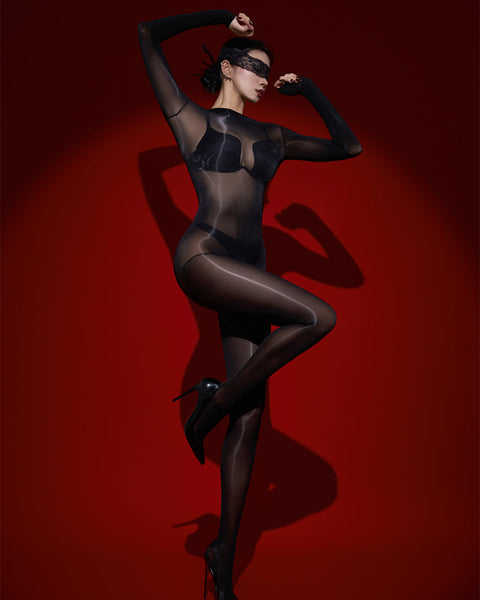 Person wearing a black bodystocking and mask on a red background