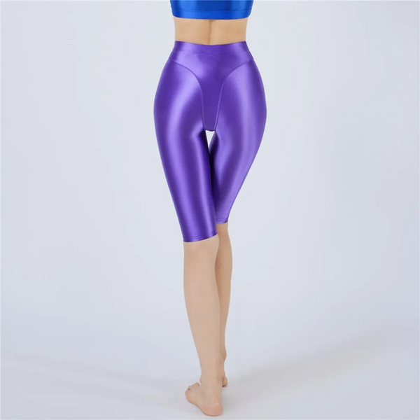 Shiny purple shorts worn by a person on a light gray background