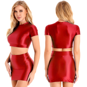 A woman posing in a red glossy short sleeves crop top with a matching red glossy mini skirts with elastic waistband.
