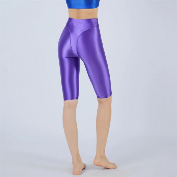 Shiny purple shorts worn by a person on a light gray background