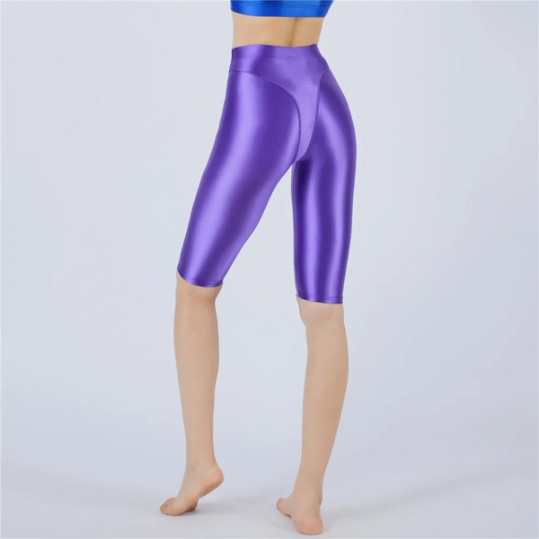 Shiny purple shorts worn by a person on a light gray background