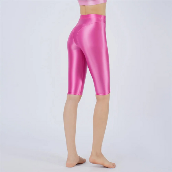 Shiny rose pink shorts worn by a person on a light gray background