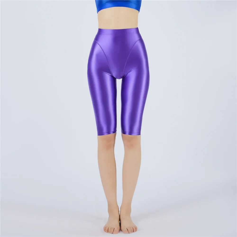 Shiny purple shorts worn by a person on a light gray background