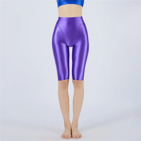 Shiny purple shorts worn by a person on a light gray background