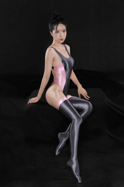Side view of lady wearing gray bodysuit with pink side panel featuring a scoop neckline, thick shoulder straps, high cut sides, thong cut back, and matching thigh high stockings.