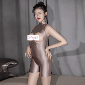Front view of lady wearing a champagne wet look bodysuit featuring a high neckline, bust cut-out, butt cheek cut-out with back zipper closure.