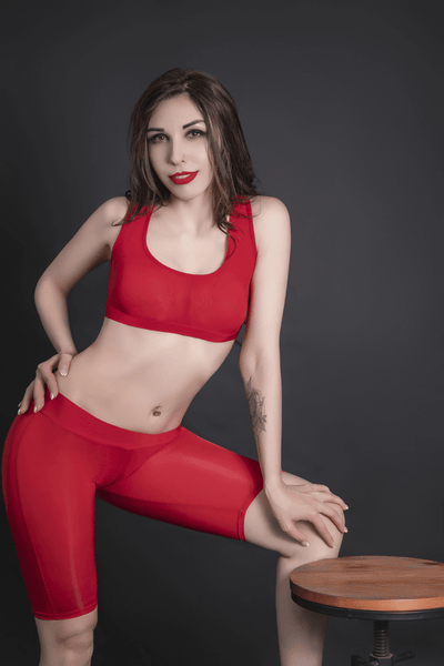 Front view of lady wearing red sports bra and matching biker shorts.