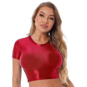 Front view of lady wearing maroon crop top featuring a round neckline, short sleeves, and a stretchy and glossy fabric.
