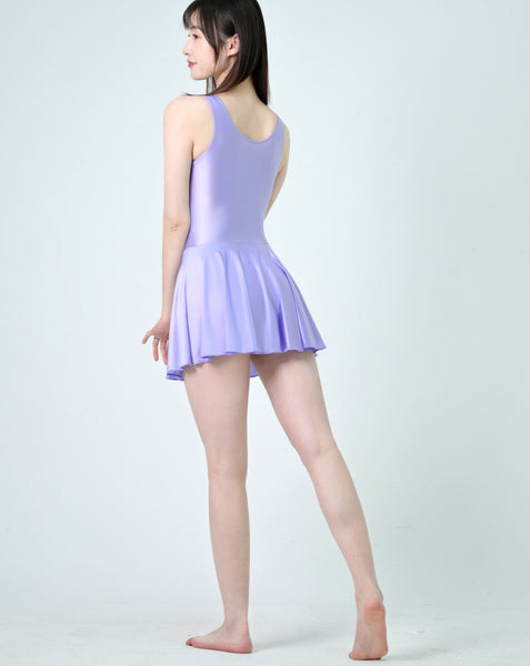 Back view of lady wearing lavender leotard dress featuring a scoop neckline, a scoop back cut, thick shoulder straps, and an attached skirt.