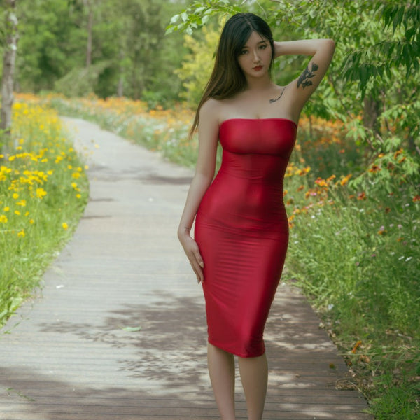 Front view of lady wearing red sheer tube dress, featuring a strapless neckline, and a criss-cross strappy back.