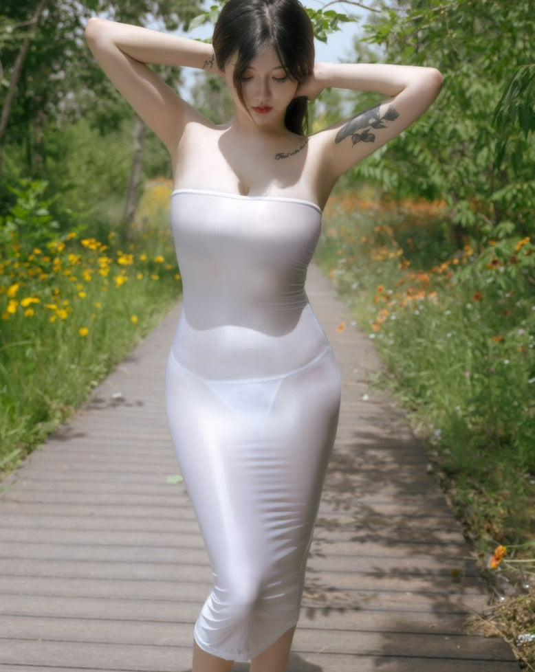Front view of lady wearing white sheer tube dress, featuring a strapless neckline, and a criss-cross strappy back.