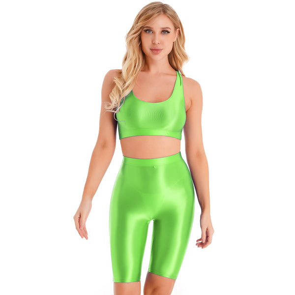 Front view of lady wearing lime green sports bra & biker shorts set featuring a sports bra with a racerback cut, thick shoulder straps, and elastic under-bust band, with matching knee-length biker shorts, and a high waist cut for additional tummy support.