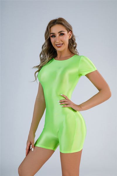 Front view of lady wearing a lime color unitard featuring a scoop neckline, short sleeves, and a glossy stretchy fabric for all-day comfort.