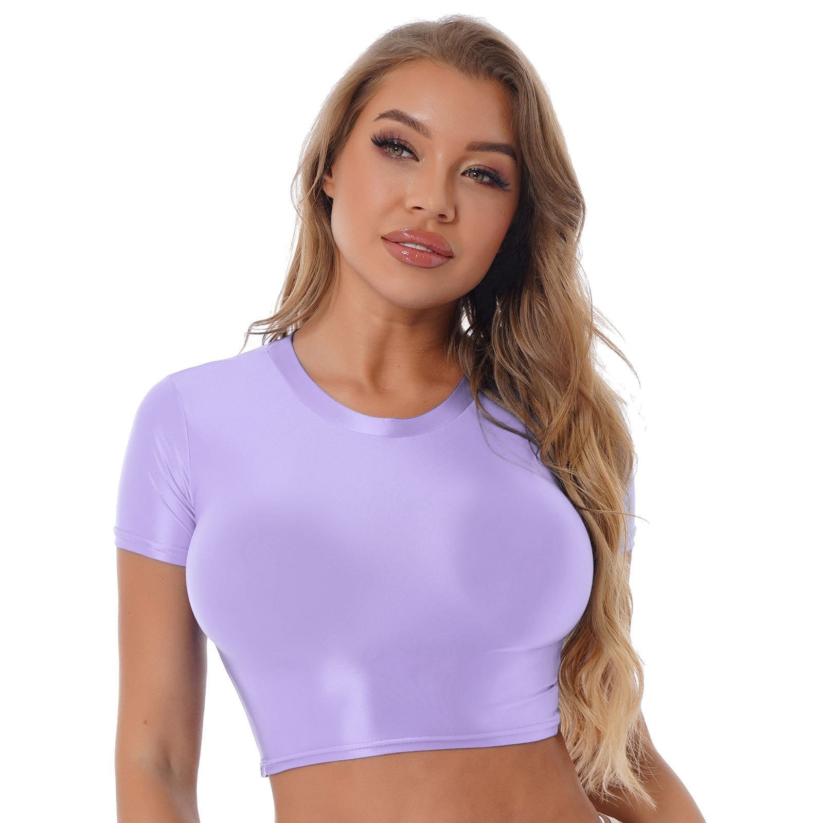 Front view of lady wearing purple crop top featuring a round neckline, short sleeves, and a stretchy and glossy fabric.