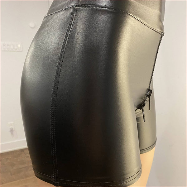 Side view of lady wearing black leather shorts featuring a front-to-back zipper closure, a high waist cut, and a wide waistband for additional support.