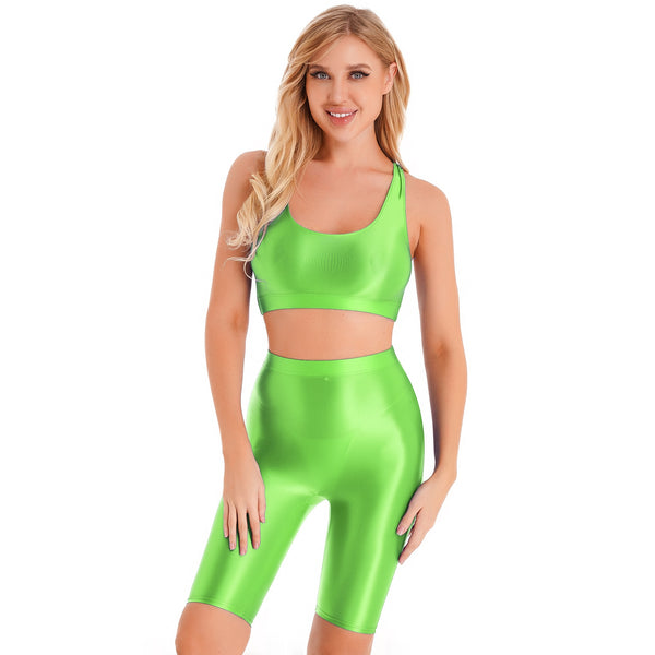 Front view of lady wearing lime green sports bra & biker shorts set featuring a sports bra with a racerback cut, thick shoulder straps, and elastic under-bust band, with matching knee-length biker shorts, and a high waist cut for additional tummy support.