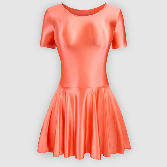 Front view of orange leotard dress featuring a scoop neckline, a scoop back cut, short sleeves, and an attached skirt.