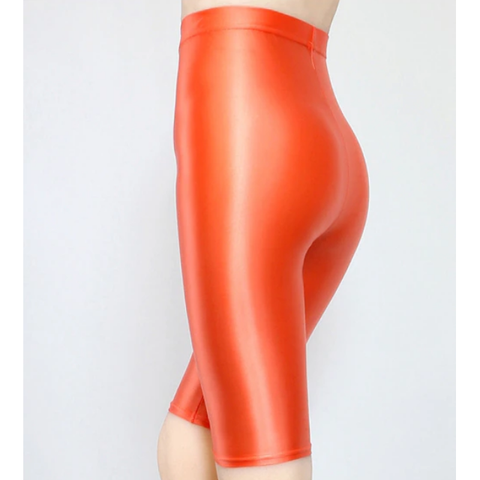 back view of lady wearing orange shiny wet look running shorts