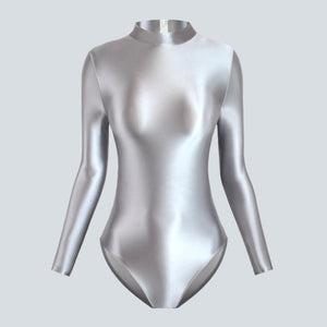 front view of silvery leotard featuring long sleeves, back zipper closure, enticing shiny wet look fabric and a cheeky cut back.