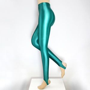 Side view of shiny wet look turquoise stirrup legging.