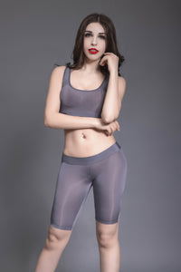 Front view of lady wearing gray color sports bra and matching biker shorts.