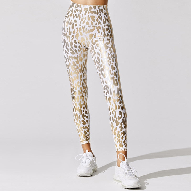 Front view of lady wearing white high waist leggings with gold shiny leopard prints and ankle length.